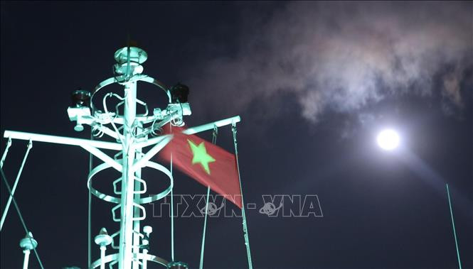 Cờ Tổ quốc trên nóc tàu Trường Sa 571 tung bay phấp phới dưới ánh trăng khi tàu đi trên vùng biển gần đảo Song Tử Tây – quần đảo Trường Sa (huyện Trường Sa, tỉnh Khánh Hoà). Ảnh: Sỹ Tuyên – TTXVN Thiêng liêng cờ Tổ quốc nơi quần đảo Trường Sa ảnh 10