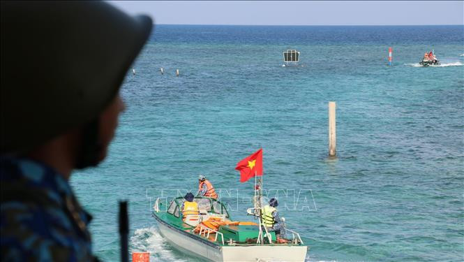 Hai chiếc xuồng của tàu Trường Sa 571 chở cán bộ và chiến sỹ từ đất liền ra thăm đảo. Ảnh: Sỹ Tuyên – TTXVN Thiêng liêng cờ Tổ quốc nơi quần đảo Trường Sa ảnh 4