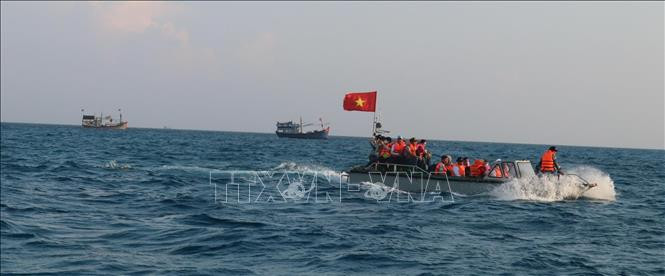 Xuồng máy của tàu Trường Sa 571 đi qua vùng biển nơi có nhiều tàu thuyền của ngư dân Việt Nam đánh bắt hải sản gần khu vực đảo Đá Tây A. Ảnh: Sỹ Tuyên – TTXVN Thiêng liêng cờ Tổ quốc nơi quần đảo Trường Sa ảnh 7