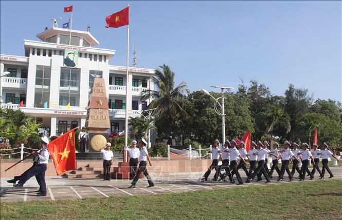 Đoàn duyệt đội ngũ mang lá “Cờ Quyết thắng đảo Song Tử Tây” đi ngang qua cột mốc đảo Song Tử Tây trong lễ chào cờ trên đảo ngày 28/4/2021 . Ảnh: Sỹ Tuyên – TTXVN Thiêng liêng cờ Tổ quốc nơi quần đảo Trường Sa ảnh 13