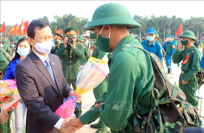Bí thư Tỉnh ủy Kon Tum Dương Văn Trang tặng hoa, động viên các công dân lên đường nhập ngũ. Ảnh: Khoa Chương – TTXVN. Kon Tum : Tiến hành lễ giao nhận quân nhanh gọn, đảm bảo công tác phòng chống dịch COVID-19 ảnh 1