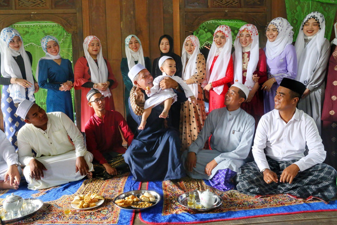 Người Chăm Islam lấy tên của 25 vị thánh để đặt tên cho đứa trẻ và tên này sẽ theo đến hết đời, nếu muốn thay đổi phải sửa soạn lễ vật tương đương như lúc đặt tên ban đầu. Ảnh: Tuấn Đức – TTXVN Tái hiện Nghi lễ đặt tên cho con của đồng bào Chăm Islam An Giang ảnh 3