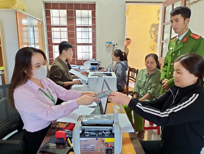 Người dân huyện miền núi Tuyên Hóa tiếp cận nguồn vốn Ngân hàng chính sách xã hội huyện. Ảnh: TTXVN phát Điểm tựa vững chắc cho hộ nghèo huyện Tuyên Hóa ảnh 1