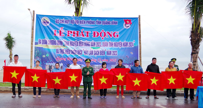 Bộ Chỉ huy Bộ đội Biên phòng tỉnh Quảng Bình trao tặng cờ Tổ quốc cho các hộ gia đình đã tích cực tham gia bảo vệ chủ quyền, an ninh biên giới vùng biển. Ảnh: TTXVN phát Nhiều hoạt động tình nguyện hướng về khu vực biên giới ảnh 2