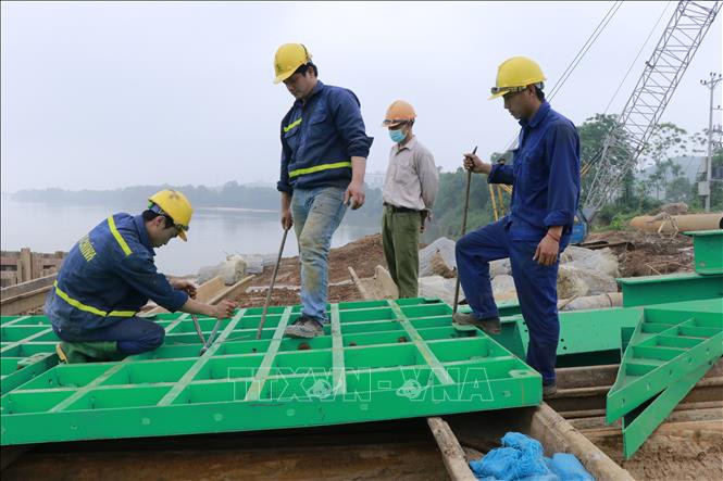 Nhà thầu thi công cầu Giới Phiên, thành phố Yên Bái đã tập trung huy động mọi nguồn lực nhằm đẩy nhanh tiến độ thi công các hạng mục của công trình để vượt lũ tiểu mãn. Ảnh: Đức Tưởng – TTXVN Yên Bái đẩy nhanh thi công cầu Giới Phiên để vượt lũ tiểu mãn ảnh 2