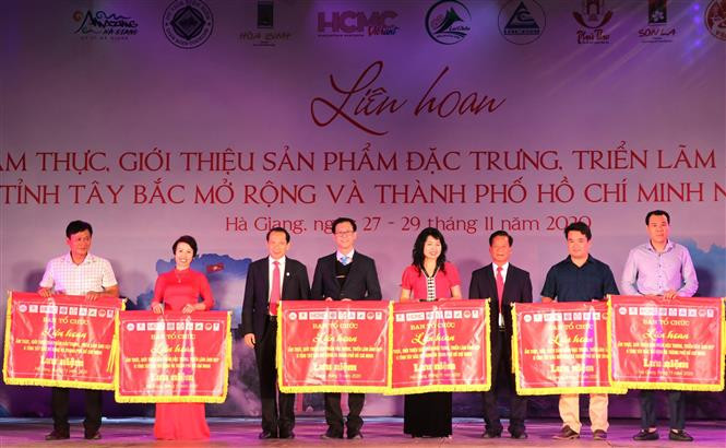 Phó Chủ tịch UBND tỉnh Hà Giang Trần Đức Quý và lãnh đạo Sở Văn hóa, Thể thao và Du lịch trao Cờ lưu niệm cho các tỉnh tham gia Liên hoan. Ảnh: Minh Tâm-TTXVN Hội tụ nét tinh hoa văn hóa ẩm thực Tây Bắc ảnh 3
