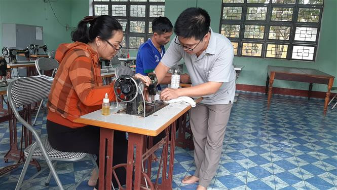 Hướng dẫn học viên tham gia khóa học may tại Trung tâm Giáo dục Nghề nghiệp - Giáo dục Thường xuyên huyện Kbang. Ảnh: Hoài Nam - TTXVN Đào tạo nghề, góp phần giảm đói nghèo vùng nông thôn Gia Lai ảnh 2