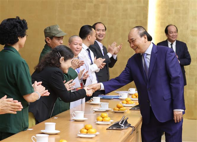 Thủ tướng Nguyễn Xuân Phúc với các đại biểu tại buổi gặp mặt. Ảnh: Thống Nhất – TTXVN Thủ tướng Nguyễn Xuân Phúc gặp mặt đại biểu dự Lễ tuyên dương "Những tấm gương sáng thầm lặng vì cộng đồng" ảnh 2