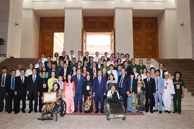 Thủ tướng Nguyễn Xuân Phúc và các đại biểu. Ảnh: Thống Nhất – TTXVN Thủ tướng Nguyễn Xuân Phúc gặp mặt đại biểu dự Lễ tuyên dương "Những tấm gương sáng thầm lặng vì cộng đồng" ảnh 3