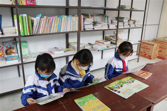 Học sinh Điểm trường Văn La đọc sách báo từ Tủ sách Đinh Hữu Dư. Ảnh: Hoàng Nguyên - TTXVN Đưa Tủ sách Đinh Hữu Dư về với học sinh ở ATK Định Hóa, Thái Nguyên ảnh 3