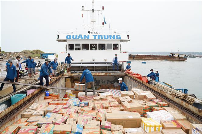 Hàng hóa và vật tư y tế được đưa lên tàu để trao tặng cho người dân huyện đảo Phú Quý. Ảnh: Hồng Hiếu - TTXVN “Chuyến tàu Tuổi trẻ - San sẻ đảo xa” tiếp sức cho huyện đảo Phú Quý chống dịch COVID-19 ảnh 1