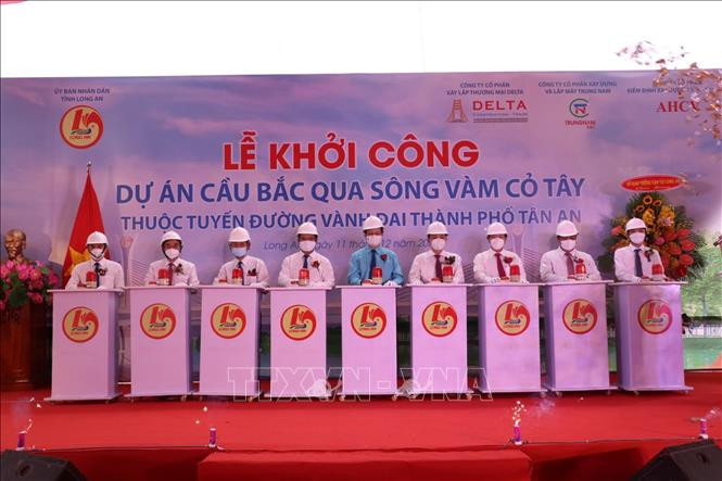 Các đại biểu thực hiện nghi thức nhấn nút, khởi công dự án. Ảnh: Bùi Giang – TTXVN Xây dựng cầu bắc qua sông Vàm Cỏ Tây ảnh 2