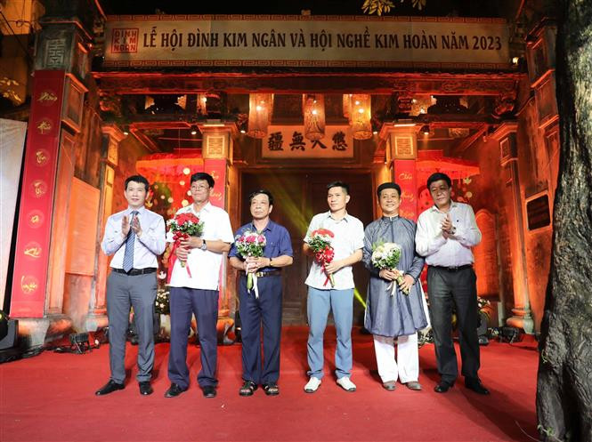 BTC tặng hoa, cảm ơn các đơn vị tham gia hoạt động trong lễ hội. Ảnh: Thanh Tùng - TTXVN Lễ hội tôn vinh ông Tổ bách nghệ tại Phố cổ Hà Nội ảnh 7