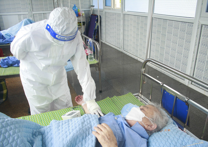 Thăm khám cho bệnh nhân mắc COVID-19 đang điều trị tại Bệnh viện Đa khoa tỉnh Ninh Bình. Ảnh: Hải Yến - TTXVN Tăng cường tiêm vaccine phòng COVID-19, ưu tiên bảo vệ nhóm nguy cơ cao ảnh 1