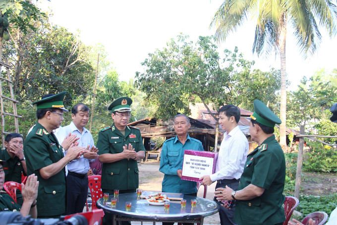 Lãnh đạo Ủy ban Trung ương Mặt trận Tổ quốc Việt Nam, Bộ Tư lệnh Bộ đội Biên phòng Việt Nam, Tỉnh ủy, UBND tỉnh Tây Ninh tặng quà cho hộ dân có hoàn cảnh khó khăn tại ấp Tân Minh, xã Tân Bình, huyện Tân Biên, tỉnh Tây Ninh. Ảnh: Thanh Tân - TTXVN Sôi nổi ngày hội Biên phòng toàn dân tại Tây Ninh ảnh 2