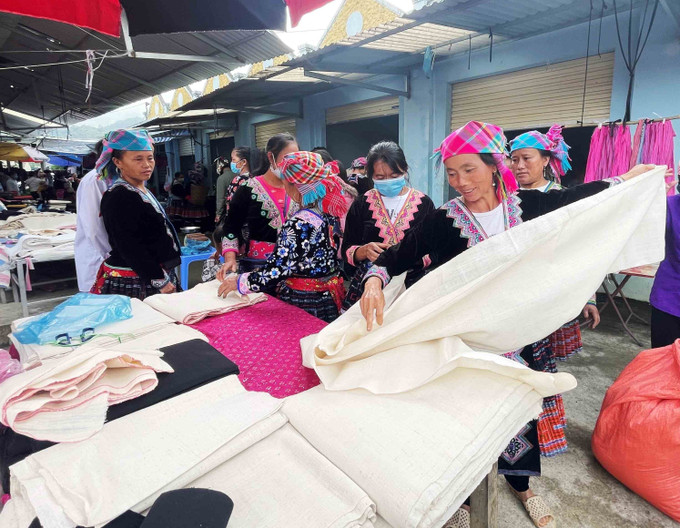 Người Mông tới chợ phiên San Thàng, thành phố Lai Châu mua vải về thêu hoa văn may trang phục truyền thống. Ảnh: Đinh Thùy-TTXVN Lai Châu: Chợ phiên góp phần gìn giữ nét văn hóa dân tộc ảnh 9