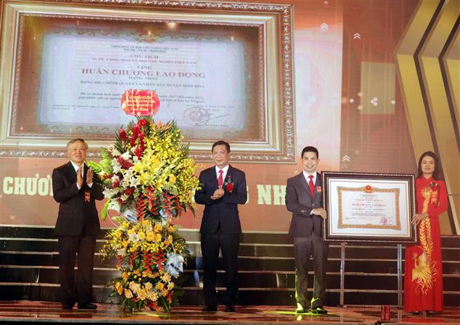 Thừa uỷ quyền Chủ tịch nước, đồng chí Nguyễn Hòa Bình, Ủy viên Bộ Chính Trị, Bí thư Trung ương Đảng, Chánh án Tòa án nhân dân tối cao trao trao Huân chương Lao động hạng Nhất cho cán bộ và nhân dân huyện Hiệp Hòa. Ảnh: Đồng Thúy-TTXVN Lễ đón nhận Bằng xếp hạng Di tích Quốc gia đặc biệt An toàn khu II Hiệp Hòa ảnh 2