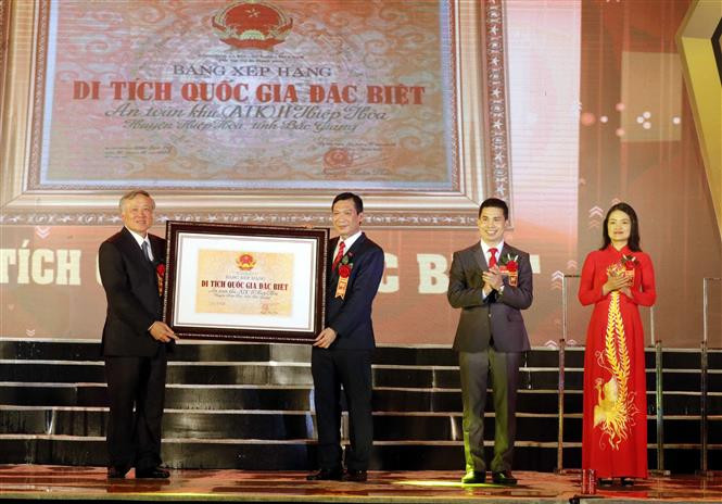 Đồng chí Nguyễn Hòa Bình, Ủy viên Bộ Chính Trị, Bí thư Trung ương Đảng, Chánh án Tòa án nhân dân tối cao trao Bằng xếp hạng Di tích Quốc gia đặc biệt An toàn khu II Hiệp Hòa cho cán bộ và nhân dân huyện Hiệp Hòa. Ảnh: Đồng Thúy-TTXVN Lễ đón nhận Bằng xếp hạng Di tích Quốc gia đặc biệt An toàn khu II Hiệp Hòa ảnh 1