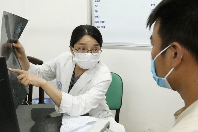 Bác sĩ Trần Thị Mai Linh khám bệnh, trao đổi với bệnh nhân. Ảnh: Đinh Hằng – TTXVN Ngày Quốc tế Phụ nữ: Bác sỹ Trần Thị Mai Linh đam mê với bộ não con người ảnh 1
