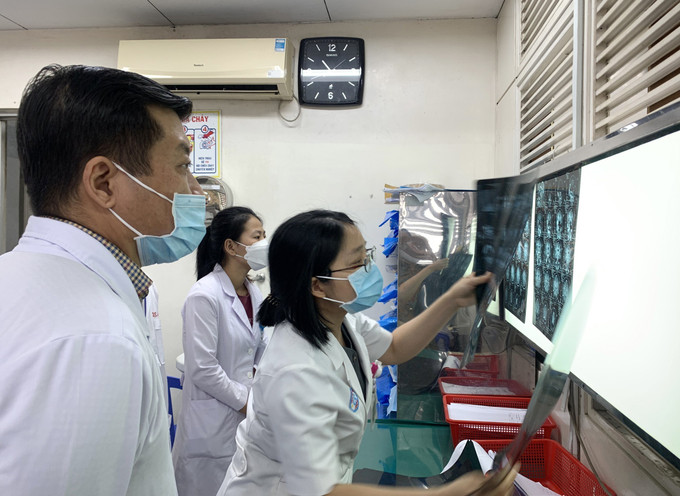 Bác sĩ Trần Thị Mai Linh hội chẩn cùng các đồng nghiệp, chuẩn bị cho một ca phẫu thuật thần kinh sọ não. Ảnh: Đinh Hằng – TTXVN Ngày Quốc tế Phụ nữ: Bác sỹ Trần Thị Mai Linh đam mê với bộ não con người ảnh 2