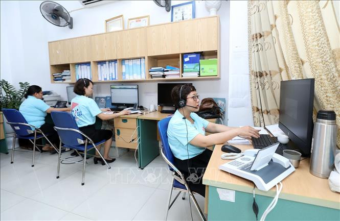 Nhân viên tư vấn của Tổng đài điện thoại quốc gia bảo vệ trẻ em 111 đặt tại Hà Nội, trả lời các cuộc gọi. Ảnh: Anh Tuấn – TTXVN Tổng đài 111 - Nơi sẻ chia, bảo vệ trẻ em ảnh 1