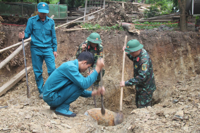 Lực lượng chức năng xử lý quả bom. Ảnh: TTXVN phát Sơn La: Hủy nổ an toàn quả bom tồn sót sau chiến tranh ảnh 1