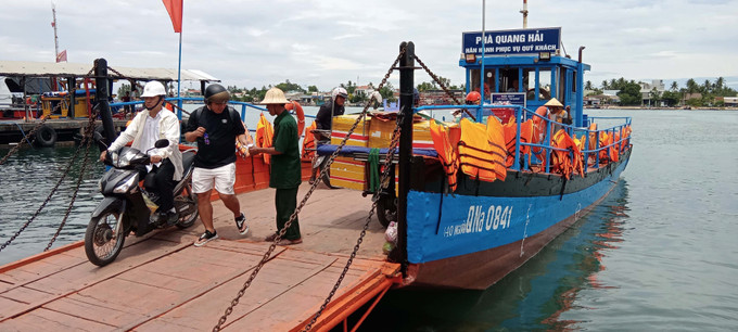Để đảo bảo an toàn, tất cả hành khách đều được kiểm soát vé, sắp xếp hàng hóa và đứng ở vị trí theo chỉ dẫn của nhân viên phục vụ. Ảnh: Đoàn Hữu Trung – TTXVN Ứng phó với áp thấp nhiệt đới: Ngư dân Quảng Nam khẩn trương tìm nơi trú ẩn an toàn ảnh 1