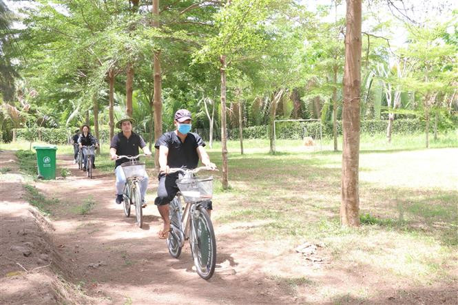 Du khách đạp xe dạo quanh nông trại xanh Riverside Garden. Ảnh: Chương Đài - TTXVN Đánh thức tiềm năng du lịch nơi 'Ba đảo dừa xanh' (Bài 1) ảnh 3