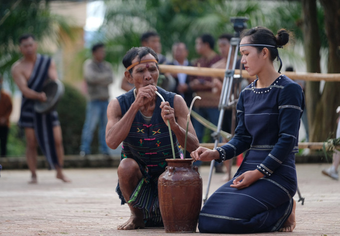 Sau khi kết thúc phần diễn tấu bài chiêng, già làng sẽ là người mở choé rượu cần, mời bà con buôn làng cùng du khách uống thử thức uống truyền thống của dân tộc mình. Ảnh: Nguyễn Dũng – TTXVN Rộn ràng lễ Mừng lúa mới của người K’Ho (Lâm Đồng) ảnh 3