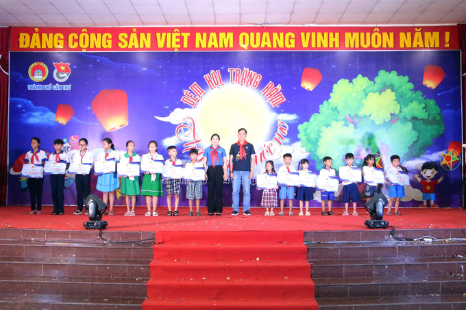Ban tổ chức trao học bổng cho thiếu nhi vượt khó học tốt trên địa bàn huyện Thới Lai. Ảnh: Trung Kiên – TTXVN Cần Thơ: Đêm hội trăng rằm “Thắp sáng ước mơ” cho thiếu nhi có hoàn cảnh khó khăn ảnh 2