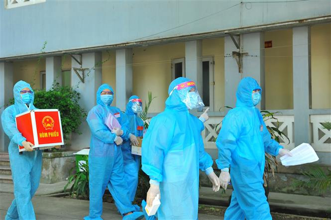 Lực lượng chức năng mang hòm phiếu đến từng phòng để cử tri thực hiện quyền bầu cử, tại đơn vị bầu cử số 7, Khu cách ly trong Trường Đại học Thể dục Thể thao, phường Trang Hạ, thị xã Từ Sơn. Ảnh: Minh Đức - TTXVN Ngày bầu cử đặc biệt tại Bắc Ninh ảnh 5