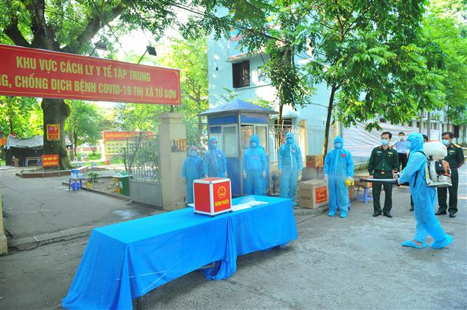 Lực lượng chức năng phun khử khuẩn khu vực bỏ phiếu bầu, tại đơn vị bầu cử số 7, Khu cách ly trong Trường Đại học Thể dục Thể thao, phường Trang Hạ, thị xã Từ Sơn. Ảnh: Minh Đức - TTXVN Ngày bầu cử đặc biệt tại Bắc Ninh ảnh 1