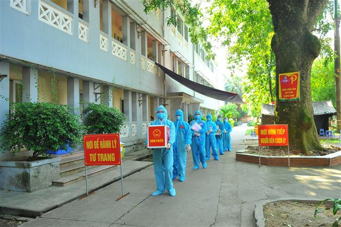 Lực lượng chức năng mang hòm phiếu đến từng phòng để cử tri thực hiện quyền bầu cử, tại đơn vị bầu cử số 7, Khu cách ly trong Trường Đại học Thể dục Thể thao, phường Trang Hạ, thị xã Từ Sơn. Ảnh: Minh Đức - TTXVN Ngày bầu cử đặc biệt tại Bắc Ninh ảnh 3