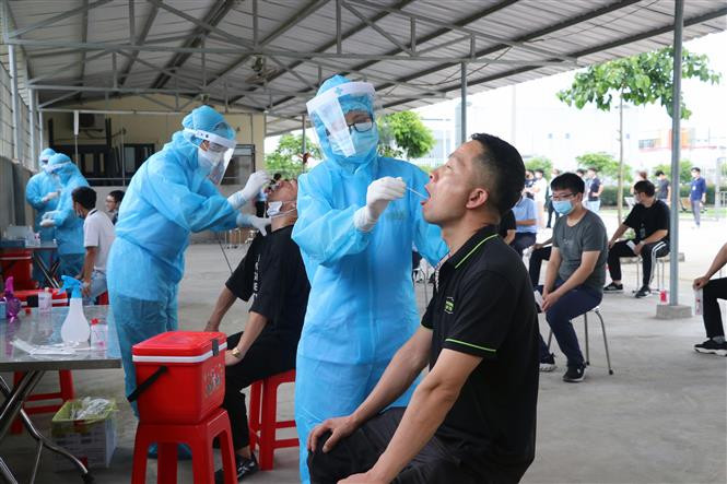Lực lượng y tế lấy mẫu xét nghiệm virus SARS-CoV-2. Ảnh: Hoàng Ngọc-TTXVN Chiều 21/5, thêm 58 ca mắc COVID-19 trong nước, riêng Bắc Giang 39 ca ảnh 1