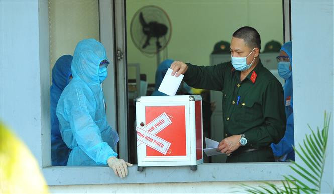 Các cử tri làm nhiệm vụ tại Khu cách ly tập trung, bỏ phiếu bầu tại đơn vị bầu cử số 7, phường Trang Hạ, thị xã Từ Sơn. Ảnh: Minh Đức - TTXVN Ngày bầu cử đặc biệt tại Bắc Ninh ảnh 4