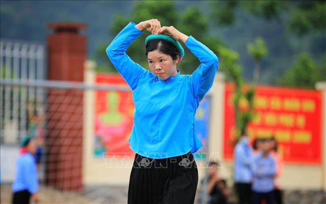 Cô gái Sán Chỉ chỉnh lại trang phục giữa trận đấu. Ảnh: Thành Đạt – TTXVN Về Bình Liêu xem bóng đá nữ ảnh 6