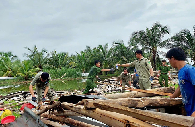 Lực lượng chức năng các địa phương đã nhanh chóng đến hỗ trợ và giúp đỡ các hộ dân sớm ổn định cuộc sống. Ảnh: TTXVN phát Cà Mau: Nhiều nhà dân bị sập, tốc mái do dông lốc ảnh 2