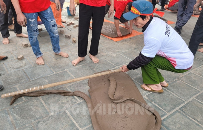 Trọng tài đo dây pháo để chấm điểm. Ảnh: baohaiduong.vn Độc đáo trò chơi dân gian pháo đất ảnh 2