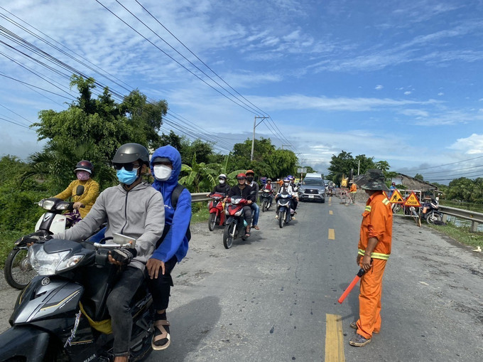 Đơn vị chức năng phân luồng giao thông nơi điểm sụp, lún thuộc tại Km 65+400,Quốc lộ 62 - Quốc lộ N2, thuộc ấp 2, xã Thủy Tây, huyện Thạnh Hóa, tỉnh Long An. Ảnh: Thanh Bình- TTXVN Long An: Khẩn trương khắc phục sạt lở nghiêm trọng tại cầu Bún Bà Của ảnh 3