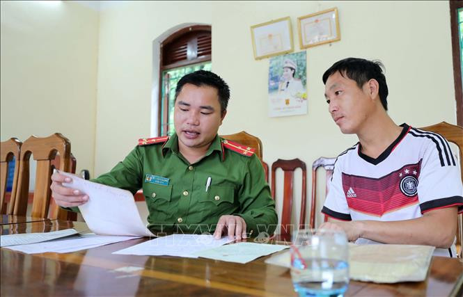 Công an viên Thượng úy Nguyễn Văn Long (Chung Chải - Mường Nhé) hướng dẫn người dân thủ tục đăng ký lưu trú trên địa bàn. Ảnh: Nhật Anh – TTXVN Tìm động lực phát triển cho cực tây Tổ quốc- Bài 1 ảnh 2