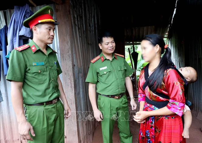 Phó Trưởng Công an huyện Mường Nhé, Thiếu tá Tống Văn Chỉnh (giữa) cùng công an xã, Thượng uý Hàng A Tu thăm chị Giàng Thị Xua (nạn nhân mua bán người) ở bản Co Lót, xã Mường Nhé. Ảnh: Nhật Anh – TTXVN Tìm động lực phát triển cho cực tây Tổ quốc- Bài 1 ảnh 5