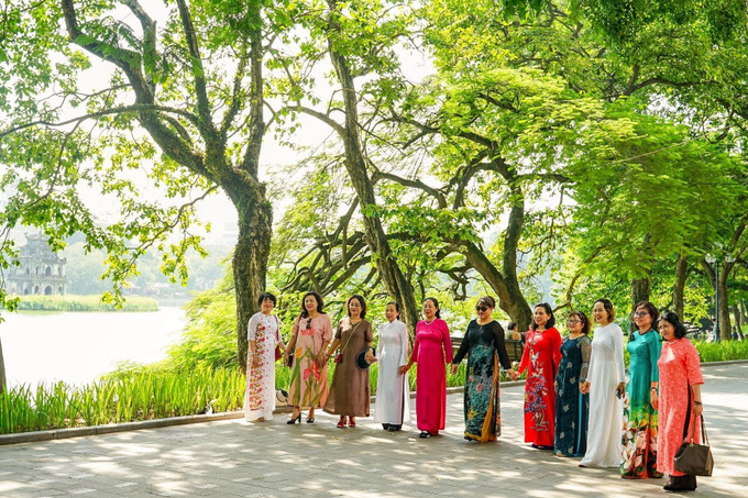 Người dân Thủ đô tranh thủ ghi lại hình ảnh Thu và áo dài Hà Nội. Ảnh: Khánh Hoà – TTXVN Hà Nội đẹp dịu dàng trong tiết Thu ảnh 12