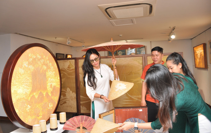 Khách tham quan tìm hiểu các sản phẩm làm từ Trúc chỉ. Ảnh: Trần Lê Lâm – TTXVN Độc đáo Triển lãm Nghệ thuật Trúc chỉ Việt Nam ảnh 1
