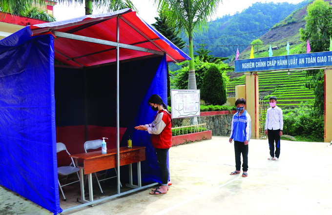 Học sinh là con em đồng bào dân tộc trên địa bàn tỉnh Yên Bái tự giác rửa tay sát khuẩn trước khi vào lớp học. Ảnh: Đức Tưởng Học sinh con em đồng bào dân tộc đi học trở lại ảnh 2