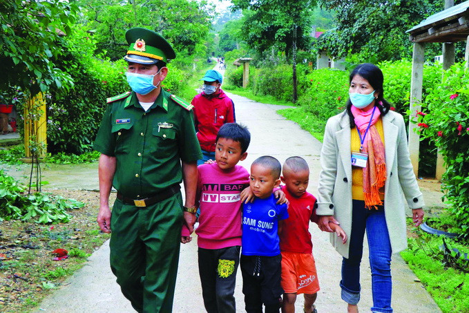 Cán bộ, chiến sĩ biên phòng và giáo viên Trường tiểu học Nhâm, xã Quảng Nhâm, huyện A Lưới (Thừa Thiên - Huế) về từng bản làng để vận động học sinh là con em đồng bào dân tộc đi học trở lại sau thời gian nghỉ học do ảnh hưởng của dịch bệnh COVID-19. Ảnh: Đỗ Trưởng Học sinh con em đồng bào dân tộc đi học trở lại ảnh 1