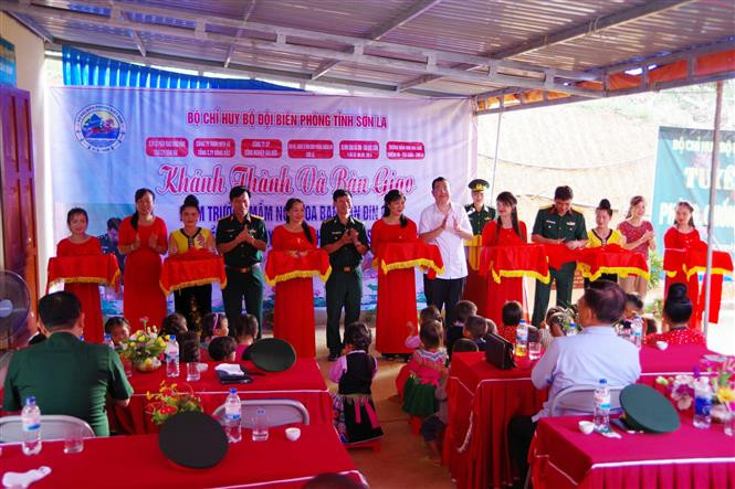 Các đại biểu cắt băng khánh thành điểm trường mầm non Hoa Ban. Ảnh: Hữu Quyết - TTXVN Bộ đội Biên phòng Sơn La chung tay xây dựng điểm trường vùng biên huyện Yên Châu ảnh 1