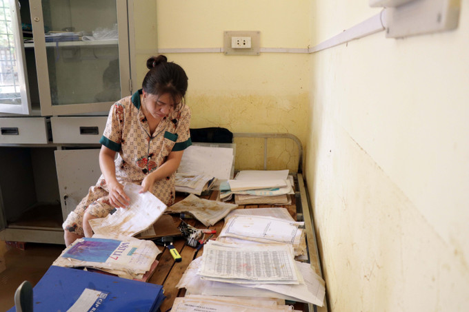 Giáo viên trường THCS Tạ Khoa, xã Tạ Khoa (Bắc Yên, Sơn La) lau dọn lại sách vở, tài liệu bị ngập trong nước lũ. Ảnh: Hữu Quyết – TTXVN Tập trung khắc phục ngập lụt, bảo đảm an toàn cho học sinh ở huyện vùng cao Bắc Yên ảnh 6