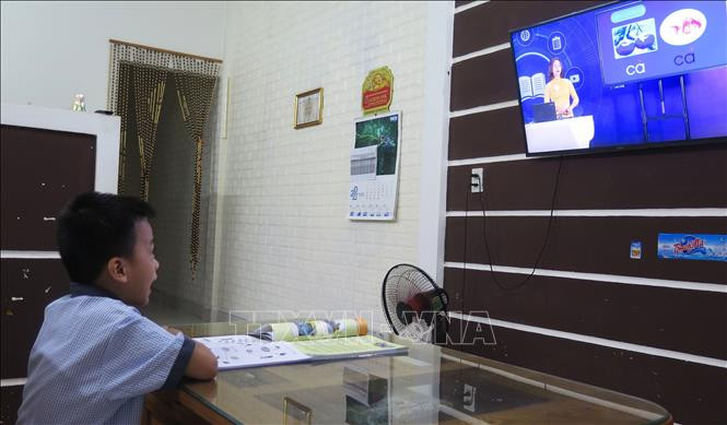 Học sinh lớp 1 học qua truyền hình. Ảnh: Tường Vi - TTXVN Thừa Thiên - Huế thực hiện nhiều hình thức dạy học phù hợp diễn biến dịch COVID-19 ảnh 1