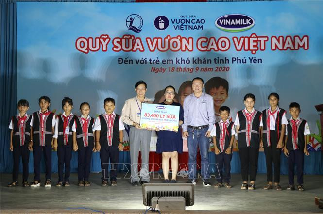 Đại diện Sở Lao động, Thương binh và Xã hội tỉnh Phú Yên, Công ty Cổ phần sữa Việt Nam (Vinamilk) trao bảng tượng trưng 83.400 li sữa cho trẻ em nghèo tỉnh Phú Yên. Ảnh: Phạm Cường-TTXVN Quỹ sữa vươn cao Việt Nam đến với trẻ em khó khăn Phú Yên ảnh 1