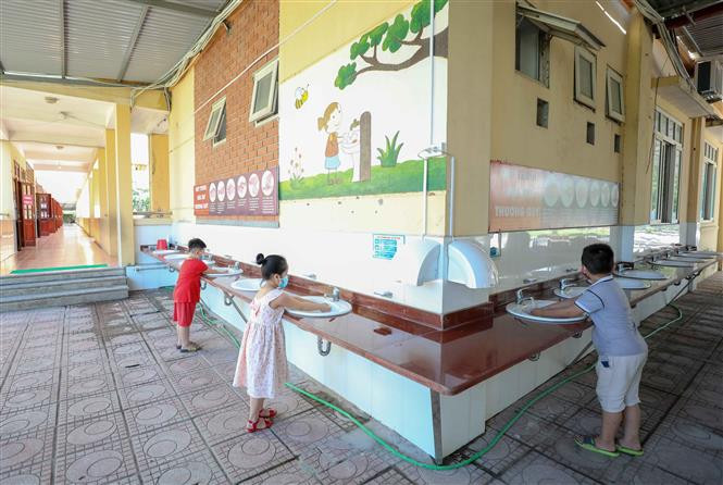 Khu vực rửa tay của học sinh được bố trí thuận lợi để các em có thể sử dụng thường xuyên. Ảnh: Thanh Tùng - TTXVN Năm học 2020 - 2021: Các trường học ở Hà Nội chủ động phòng, chống dịch COVID-19 ảnh 3